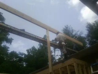 Carpenter setting a ridge beam over a new addition frame — Ice Dam Removal by Roofing Brothers in Parker Ford