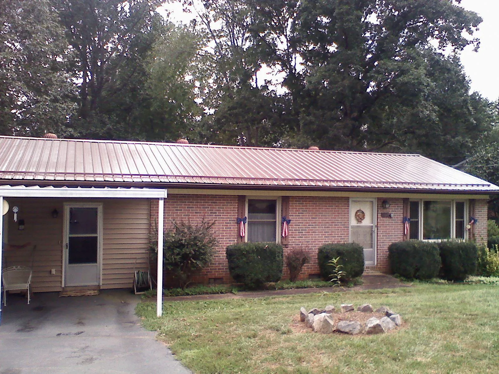 Bronze metal roof and carport on a brick ranch home — Roof Repair work by our crew in Parker Ford